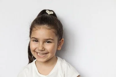 Portrait of a happy smiling latin child girl on white background